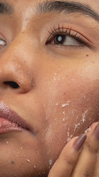 Model applying Noni Gentle Peeling Gel on dry skin, gently massaging for exfoliation, showing visible dead skin removal.